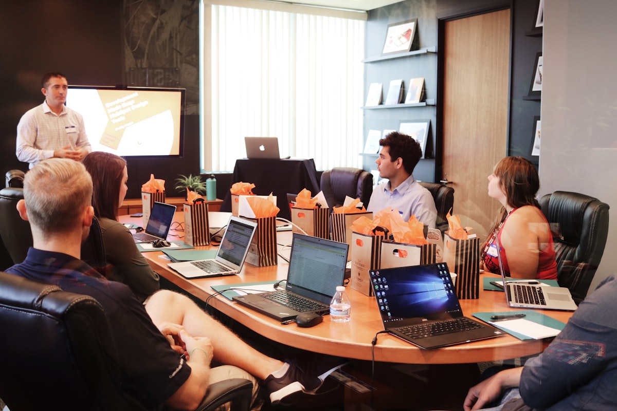 A facilitator presenting to colleagues around a table during a corporate workshop
