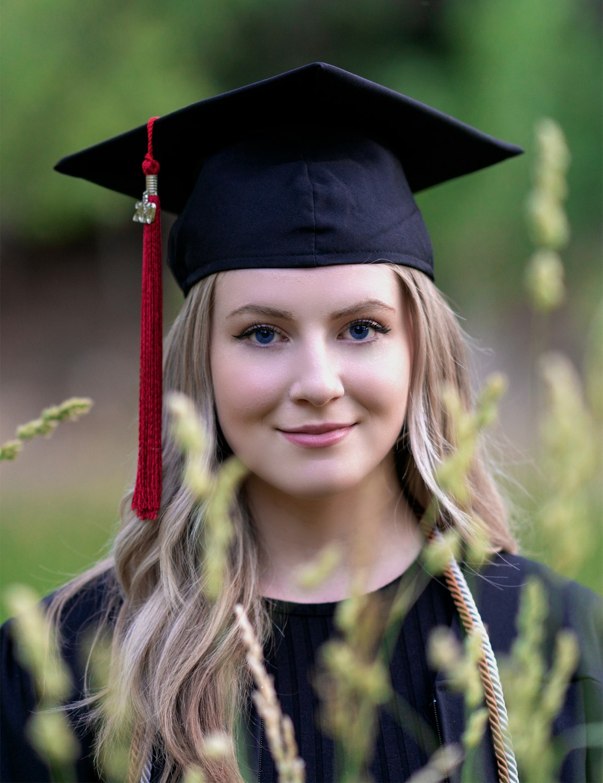A smiling fresh graduate in cap and gown, representing the start of a career journey